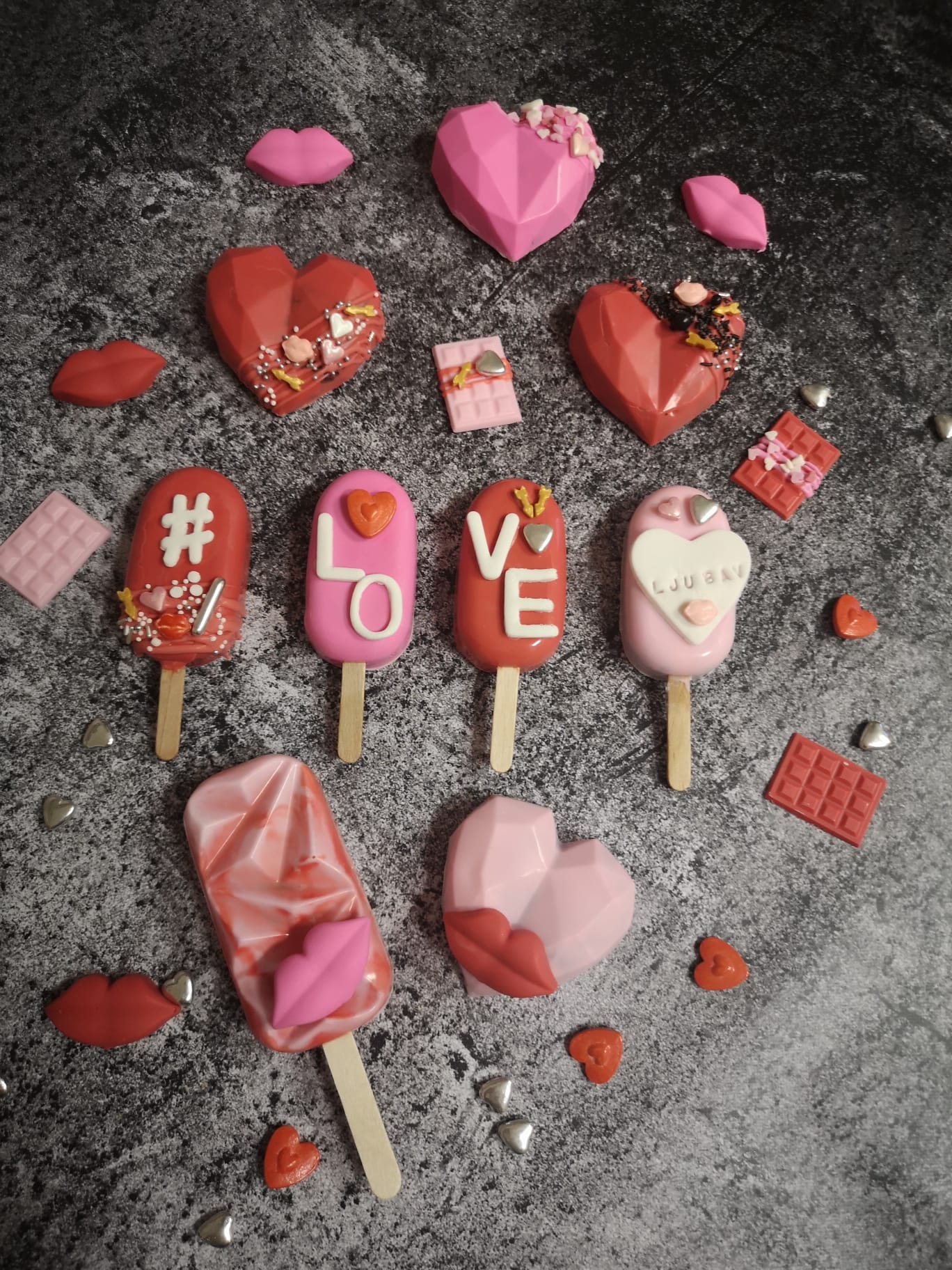 Valentinovska kolekcija cakesicla s natpisom LOVE te čokoladna srca i usnice u crvenoj i roza čokoladi s mini pločicama čokolade